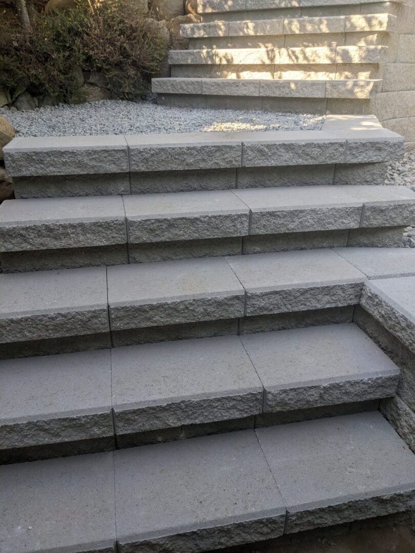 A series of granite stairs leading upward with sunlight casting shadows on the steps.